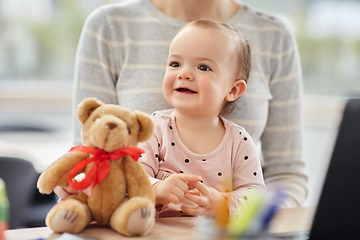 Image showing happy baby with mother working at home office