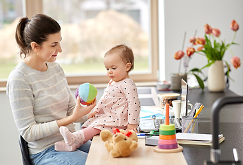 Image showing happy mother with baby working at home office