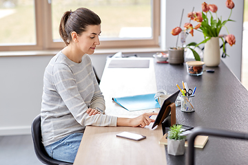 Image showing young woman with tablet pc working at home office