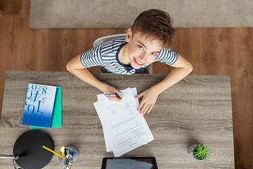 Image showing happy student boy writing test at home