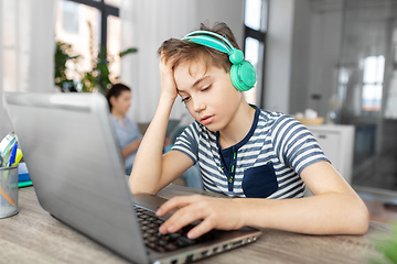 Image showing sad boy with laptop and headphones at home