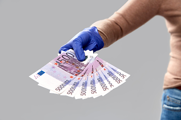 Image showing close up of hand in medical glove with money