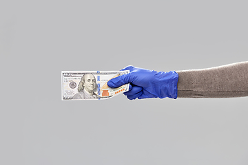 Image showing close up of hand in medical glove with money