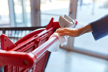 Image showing hand cleaning shopping cart handle with wet wipe