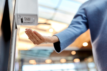 Image showing close up of woman at dispenser with hand sanitizer