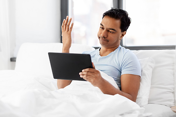 Image showing indian man with tablet pc in bed at home