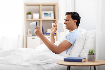 Image showing happy man with tablet pc in bed having video call