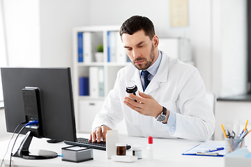 Image showing male doctor with medicine and computer at hospital