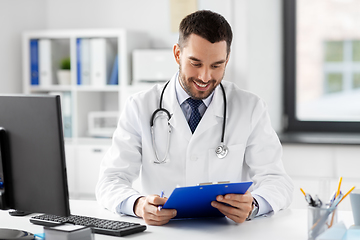 Image showing smiling male doctor with clipboard at hospital