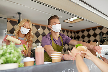 Image showing sellers in masks serving customers at food truck