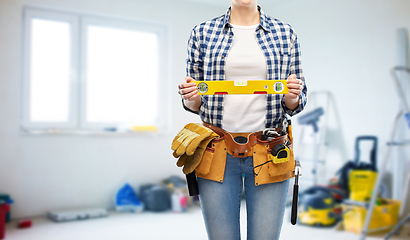 Image showing woman builder with level and working tools on belt