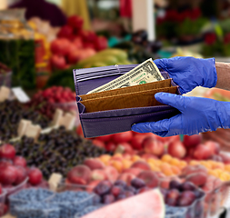 Image showing close up of hands in gloves with empty wallet