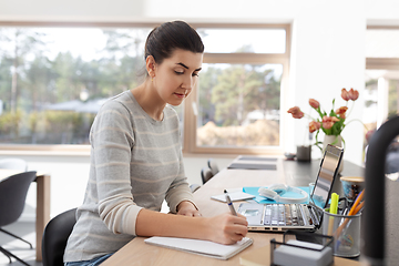 Image showing young woman with laptop working at home office