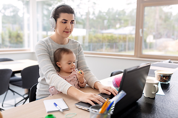 Image showing mother with baby working on laptop at home office