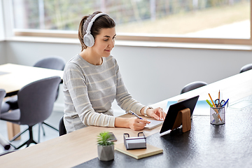 Image showing woman in headphones with tablet pc working at home
