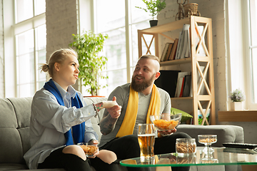 Image showing Excited family watching football, sport match at home, beautiful couple