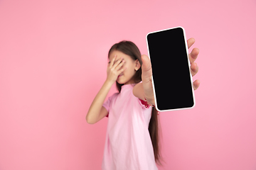 Image showing Caucasian little girl portrait isolated on pink studio background, emotions concept