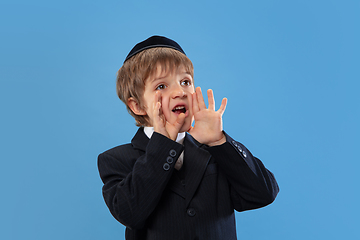 Image showing Portrait of a young orthodox jewish boy isolated on blue studio background, meeting the Passover