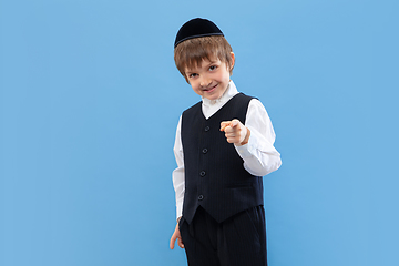 Image showing Portrait of a young orthodox jewish boy isolated on blue studio background, meeting the Passover