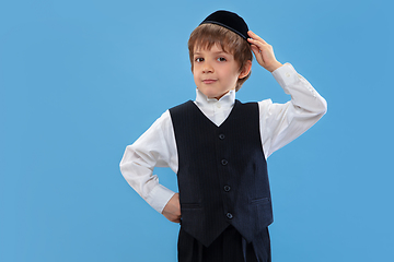 Image showing Portrait of a young orthodox jewish boy isolated on blue studio background, meeting the Passover