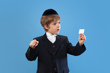 Image showing Portrait of a young orthodox jewish boy isolated on blue studio background, meeting the Passover