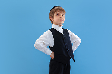 Image showing Portrait of a young orthodox jewish boy isolated on blue studio background, meeting the Passover