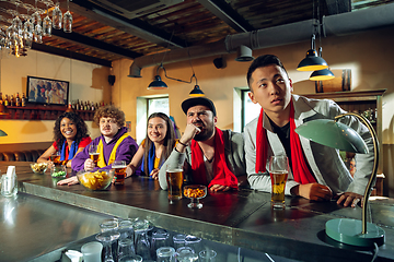 Image showing Sport fans cheering at bar, pub and drinking beer while championship, competition is going