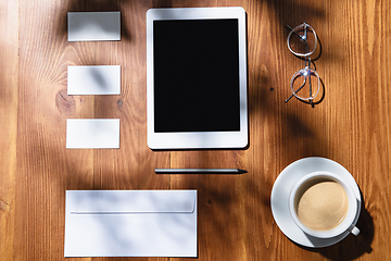 Image showing Creative and cozy workplace at home office, inspirational mock up with plant shadows on table surface