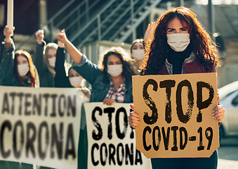 Image showing Young people in face masks protesting of stop coronavirus pandemic on the street