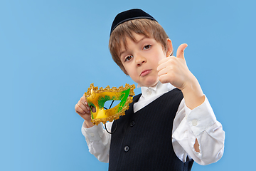 Image showing Portrait of a young orthodox jewish boy isolated on blue studio background, meeting the Passover