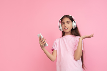 Image showing Caucasian little girl portrait isolated on pink studio background, emotions concept