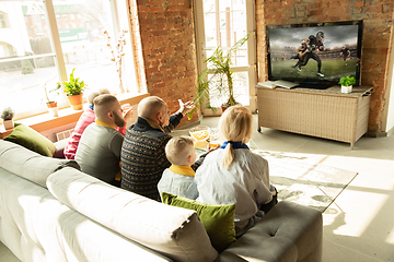 Image showing Excited family watching american football, sport match at home