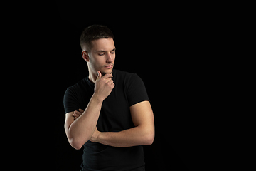 Image showing Monochrome portrait of young caucasian man on black studio background