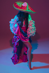 Image showing Fabulous Cinco de Mayo female dancer on purple studio background in neon light