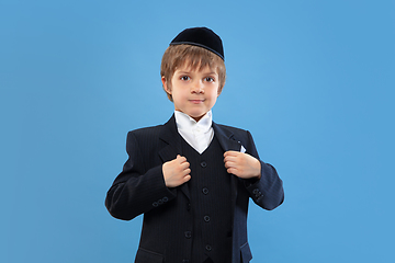 Image showing Portrait of a young orthodox jewish boy isolated on blue studio background, meeting the Passover