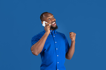 Image showing Monochrome portrait of young african-american man on blue studio background