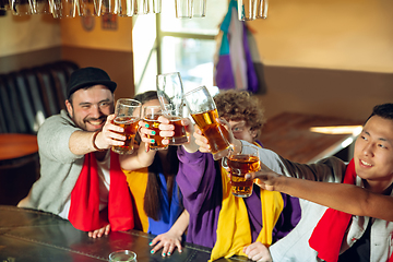 Image showing Sport fans cheering at bar, pub and drinking beer while championship, competition is going