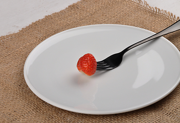 Image showing Strawberry on fork and plate