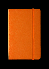 Image showing Orange closed notebook isolated on black