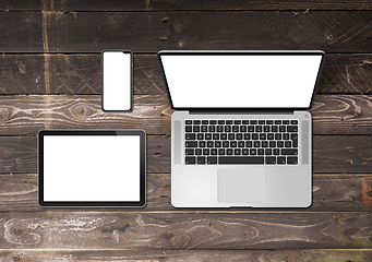 Image showing Laptop, tablet and phone set mockup on a wooden background. 3D r