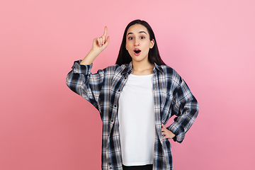 Image showing Caucasian woman\'s portrait isolated on coral pink studio background with copyspace