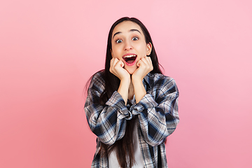 Image showing Caucasian woman\'s portrait isolated on coral pink studio background with copyspace