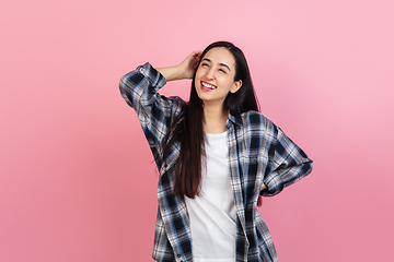 Image showing Caucasian woman\'s portrait isolated on coral pink studio background with copyspace