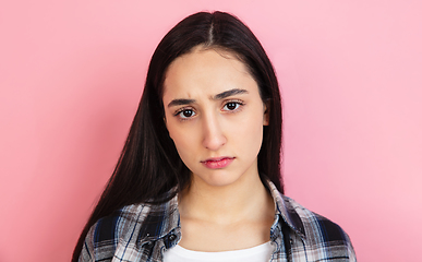 Image showing Caucasian woman\'s portrait isolated on coral pink studio background with copyspace