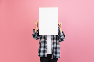 Image showing Caucasian woman\'s portrait isolated on coral pink studio background with copyspace