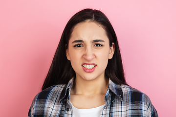 Image showing Caucasian woman\'s portrait isolated on coral pink studio background with copyspace