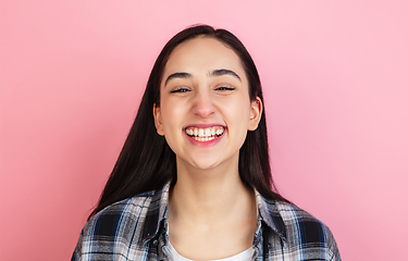 Image showing Caucasian woman\'s portrait isolated on coral pink studio background with copyspace