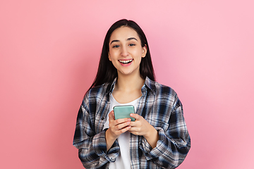 Image showing Caucasian woman\'s portrait isolated on coral pink studio background with copyspace