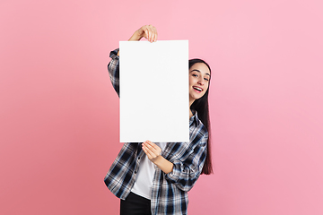 Image showing Caucasian woman\'s portrait isolated on coral pink studio background with copyspace