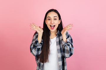 Image showing Caucasian woman\'s portrait isolated on coral pink studio background with copyspace